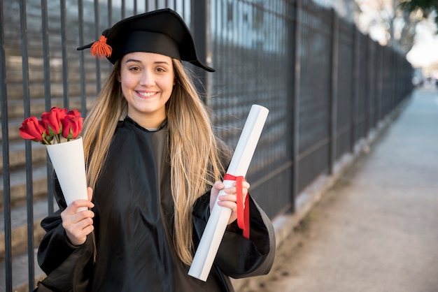 Jovem licenciado com buquê de rosas