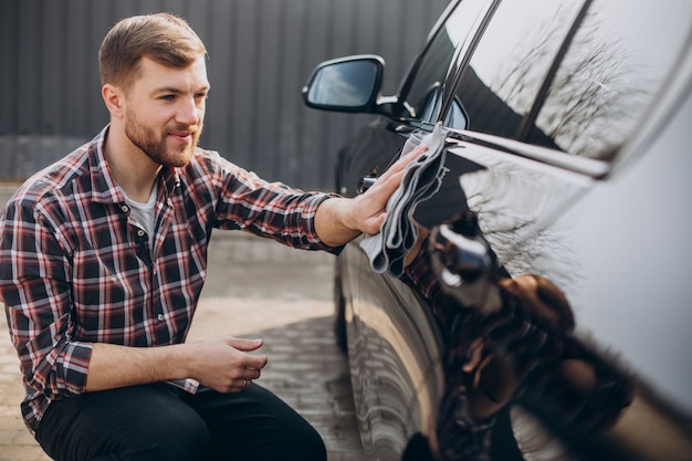 Jovem limpando o carro após a lavagem