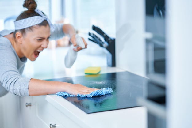 Jovem limpando sujeira na cozinha