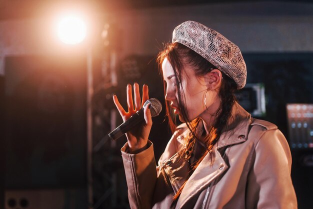 Jovem linda cantora ensaiando em um estúdio de gravação