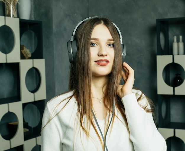 Jovem linda com roupa casual curtindo a música em casa