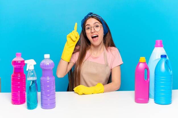 Jovem, linda dona da casa se sentindo um gênio feliz e animado depois de realizar uma ideia, levantando o dedo alegremente, eureka!