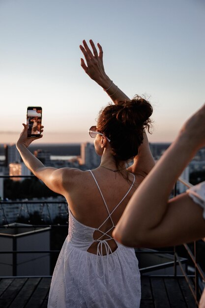 jovem linda é fotografada no celular em uma festa ao ar livre