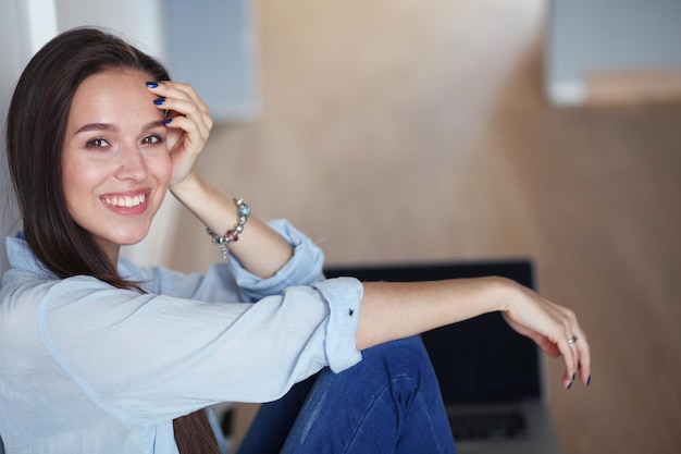 Jovem linda em casa sentada no chão com laptop Jovem linda mulher