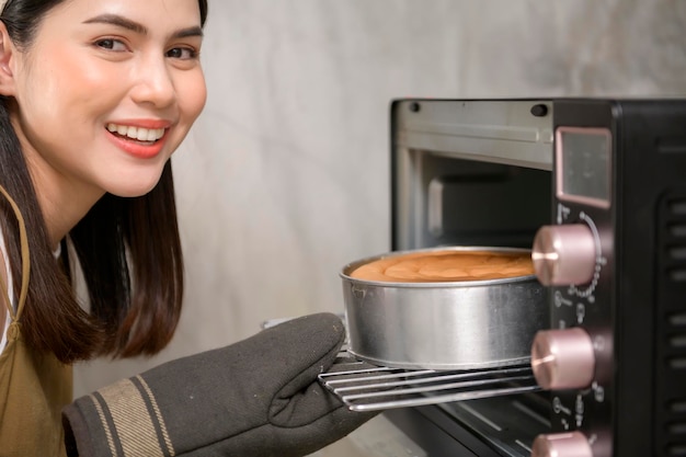 Jovem linda está assando em sua padaria de cozinha e negócios de cafeteria