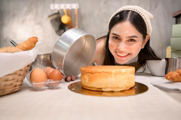 Jovem linda está assando em sua padaria de cozinha e negócios de cafeteria