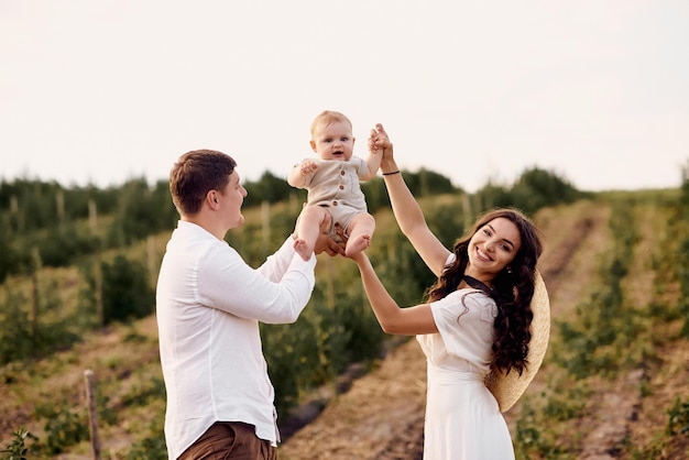 Jovem linda família com bebê no campo