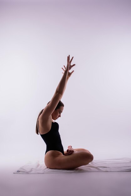 Jovem linda fêmea de ioga posando em um fundo de estúdio