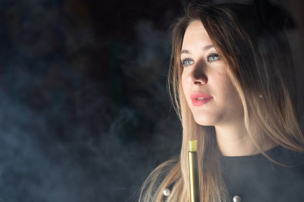 Jovem, linda garota fuma um cachimbo de água