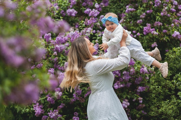 Jovem linda mãe com filha de 15 anos em lilás florescendo Família feliz no parque Primavera