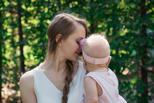 Jovem linda mãe segurando a menina. Conceito de maternidade feliz