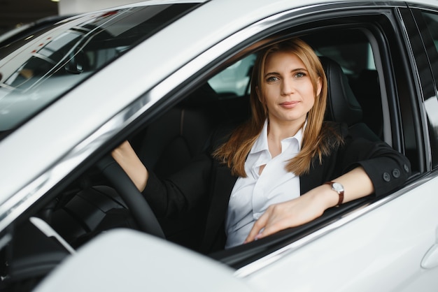 Jovem linda mulher de negócios sentada no carro