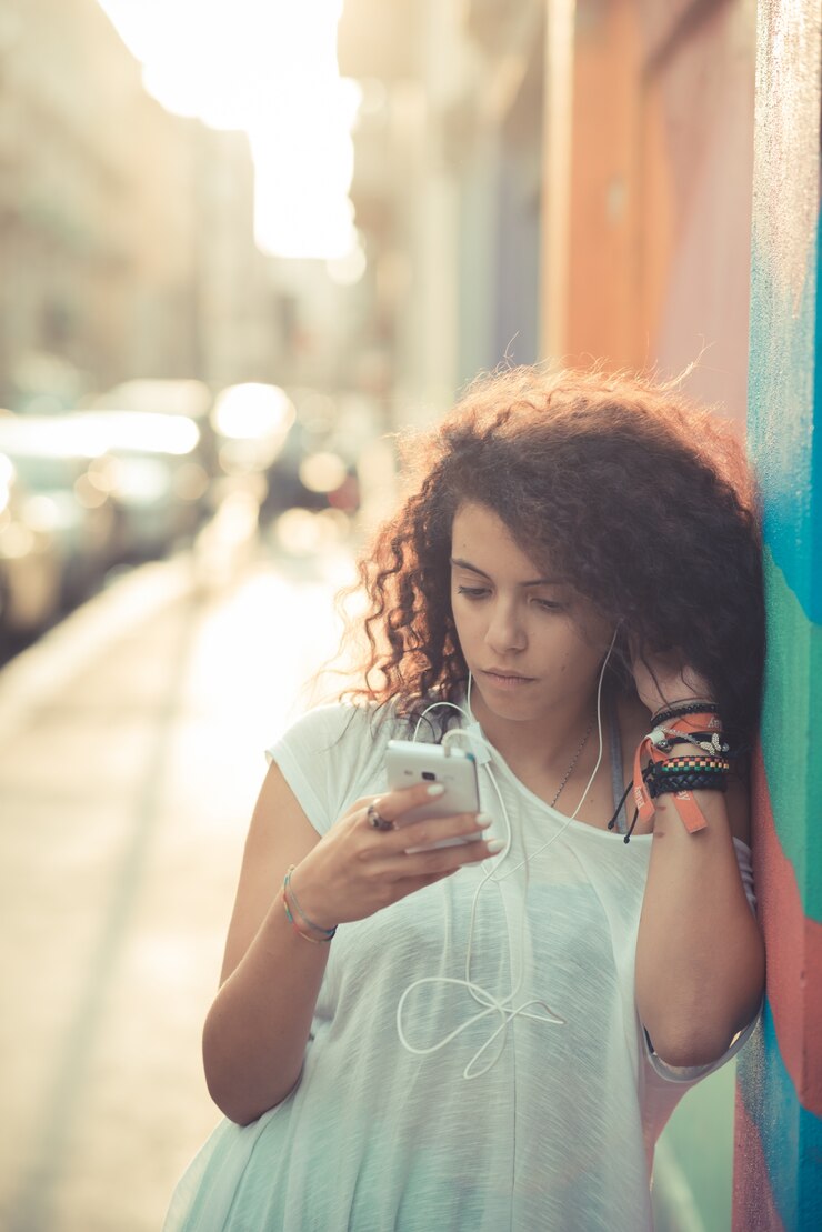 Foto jovem linda mulher encaracolada marroquina usando smartphone