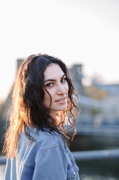 Jovem linda mulher hipster sorridente em roupas da moda de verão Modelo despreocupado sexy posando no fundo da rua europa ao pôr do sol Fêmea morena positiva Alegre e feliz