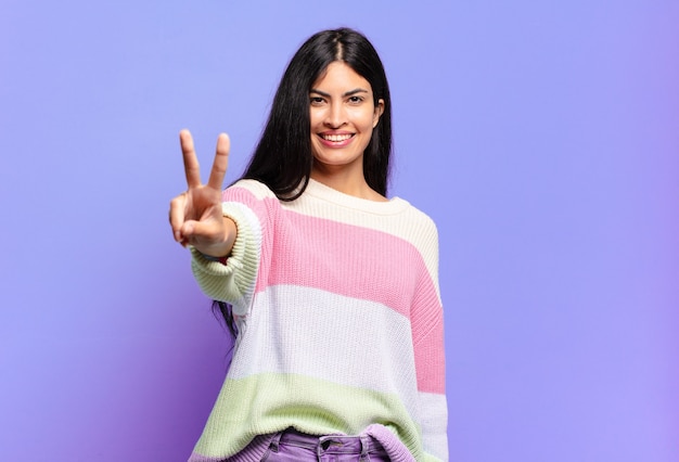 Jovem, linda mulher hispânica sorrindo e parecendo amigável