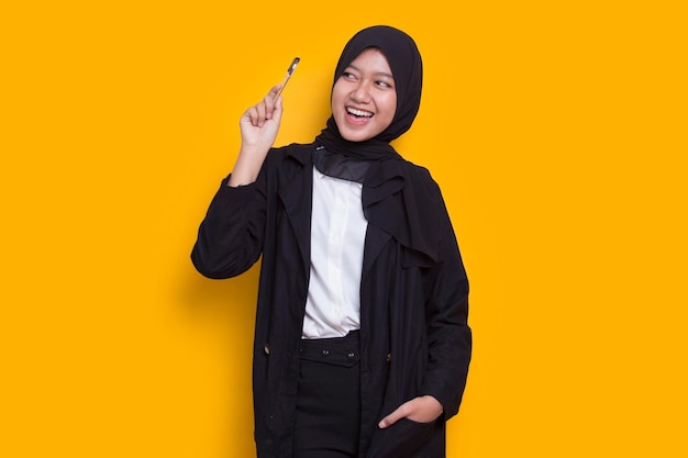 jovem linda mulher muçulmana asiática pensando na ideia isolada em fundo amarelo