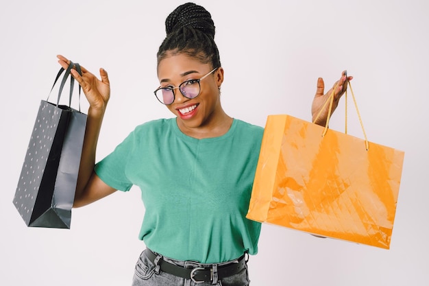 Jovem linda mulher negra carregando sacolas de compras e se sentindo animada