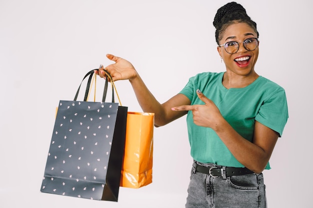 Jovem linda mulher negra carregando sacolas de compras e se sentindo animada