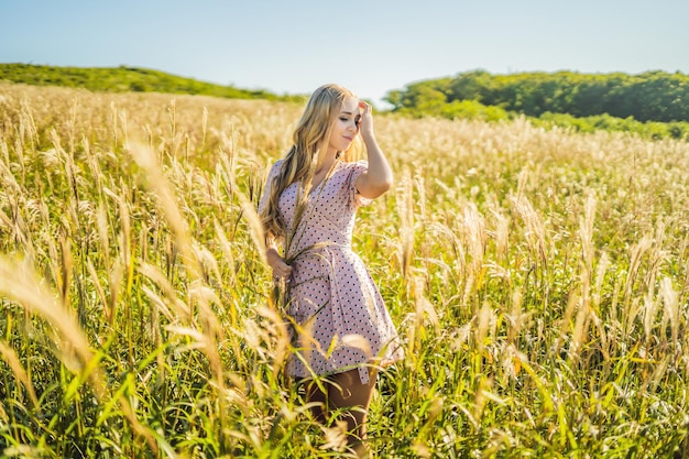 Jovem linda na paisagem de outono com flores secas picos de trigo Moda outono inverno Foto de moda outono ensolarado