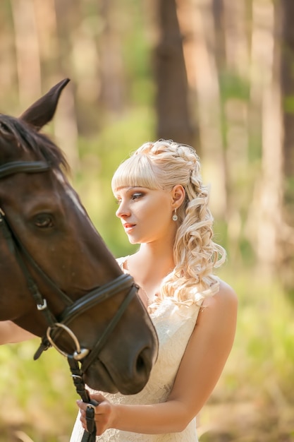 Jovem linda noiva e cavalo na natureza