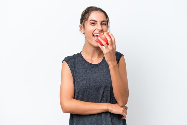 Jovem linda uruguaia isolada no fundo branco comendo uma maçã