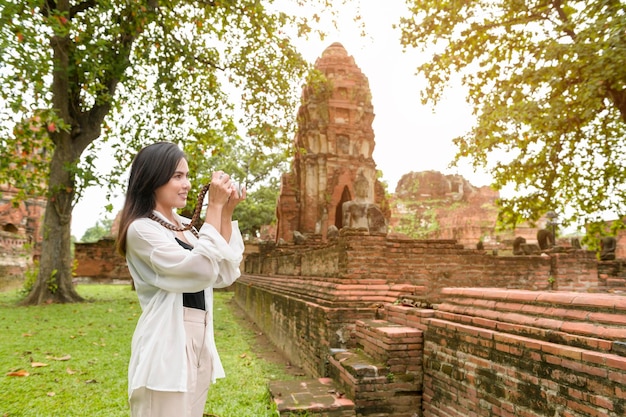 Jovem linda viajando e tirando fotos no parque histórico tailandês
