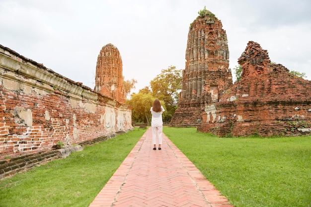 Jovem linda viajando e tirando fotos no parque histórico tailandês