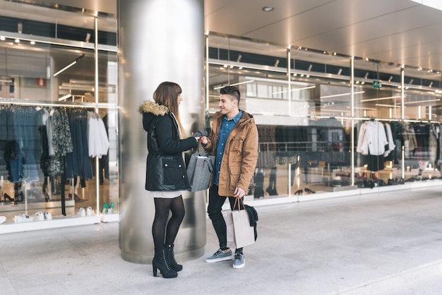 Jovem lindo casal apaixonado, fazer compras na rua