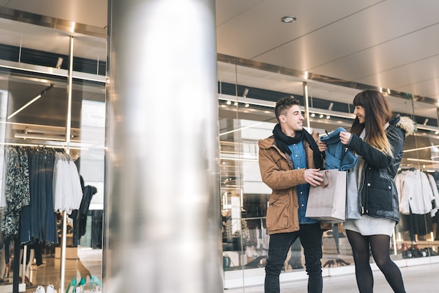 Jovem lindo casal apaixonado, fazer compras na rua