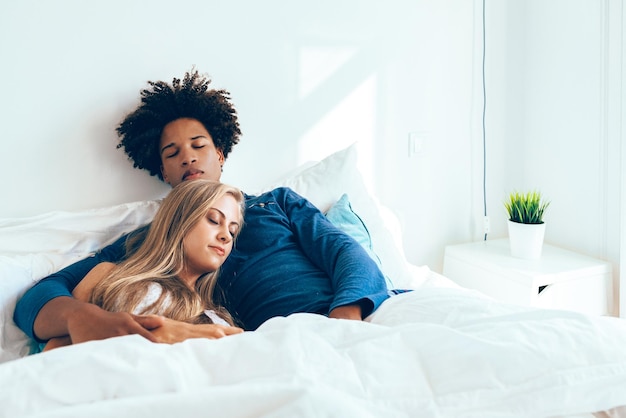 Jovem lindo casal interracial na cama dormindo