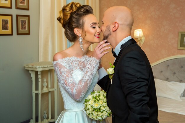 Jovem lindo casal recém-casado em ternos de casamento sorrindo