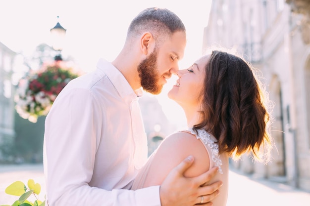 Jovem lindo casal sorridente feliz posando na rua da cidade velha Os modelos se abraçam e se olham