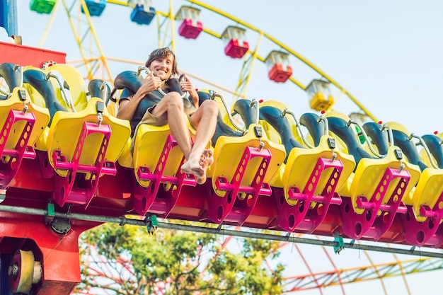 Jovem lindo se divertindo em um parque de diversões