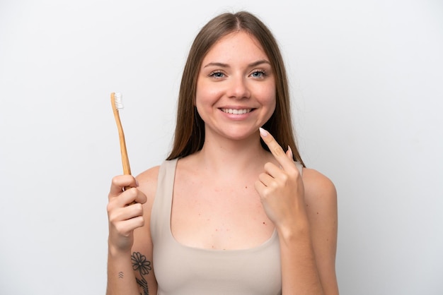 Jovem lituana isolada em fundo branco com escova de dentes e expressão feliz