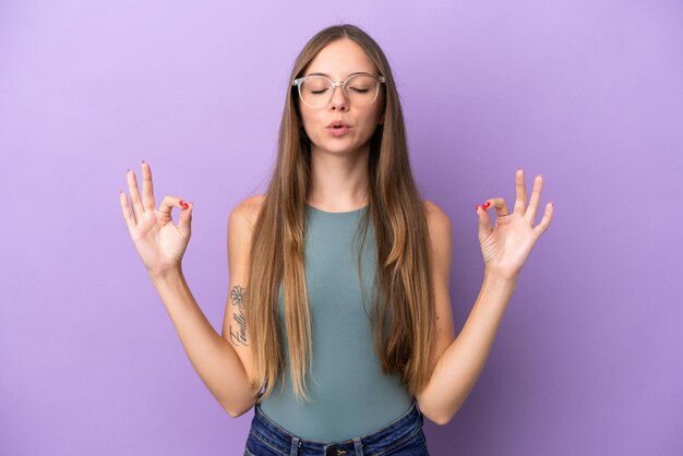 Jovem lituana isolada em fundo roxo em pose zen