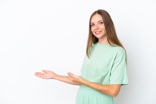 Jovem lituana isolada em um fundo branco, estendendo as mãos para o lado para convidar para vir