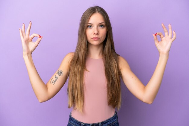 Jovem lituana isolada em um fundo roxo em pose zen