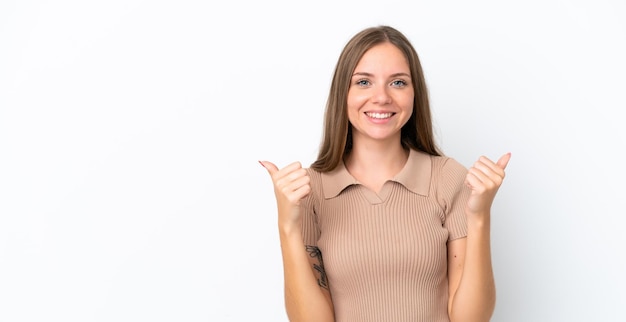 Jovem lituana isolada no fundo branco com gesto de polegar para cima e sorrindo