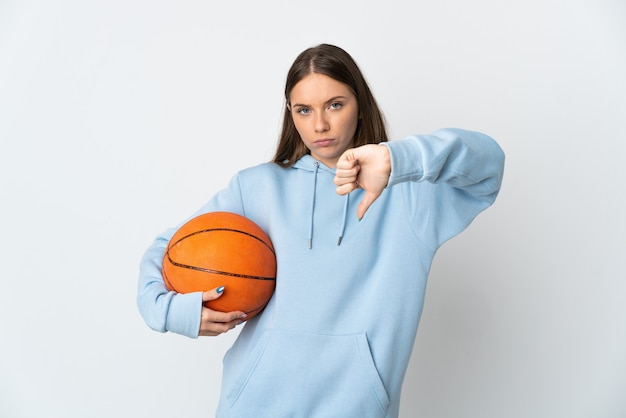 Jovem lituana jogando basquete, isolada na parede branca, mostrando o polegar para baixo com expressão negativa