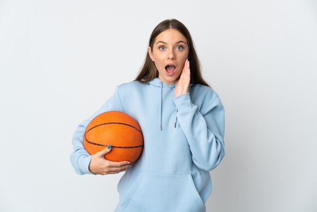 Jovem lituana jogando basquete, isolada no fundo branco, com expressão facial surpresa e chocada