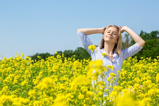 Jovem loira bonita descansando em um prado florido