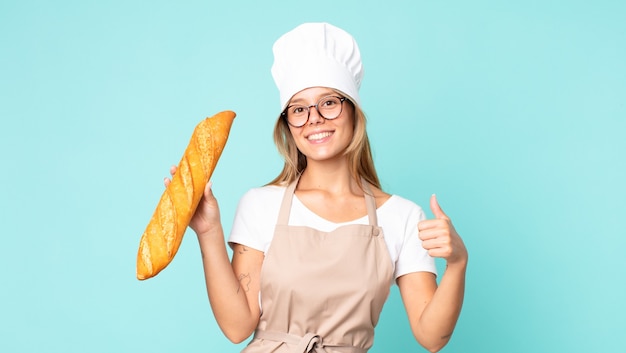 Jovem loira chef segurando uma baguete de pão