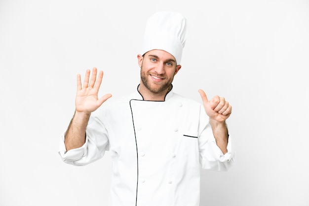 Jovem loira Chef sobre fundo branco isolado, contando seis com os dedos