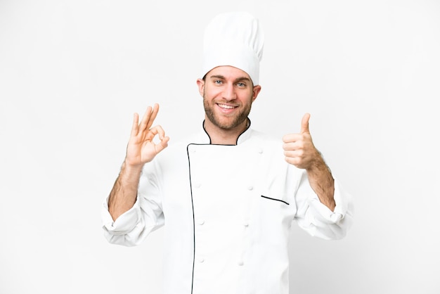 Jovem loira Chef sobre fundo branco isolado mostrando sinal ok e polegar para cima gesto