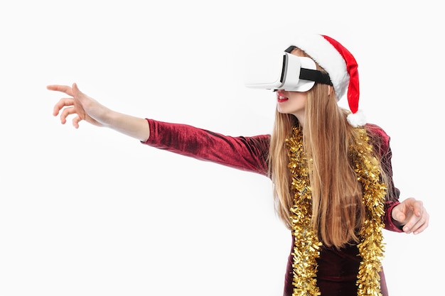 Jovem loira com chapéu de Papai Noel e fone de ouvido VR