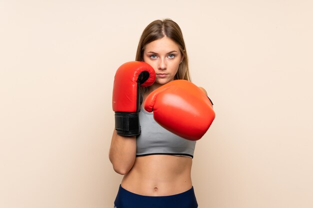 Jovem loira com luvas de boxe sobre fundo isolado