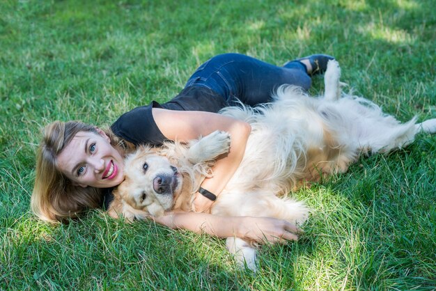 Jovem loira com seu cachorro retriever ao ar livre.