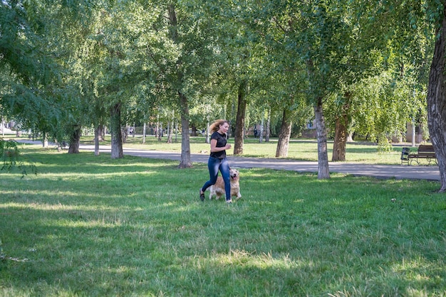 Jovem loira com seu cachorro retriever no parque