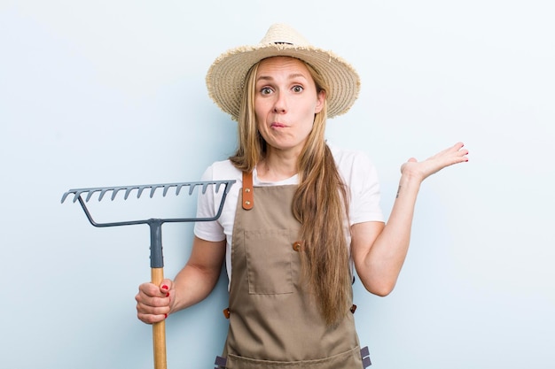 Jovem loira com um conceito de agricultor de ancinho