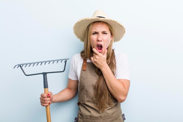 Jovem loira com um conceito de agricultor de ancinho